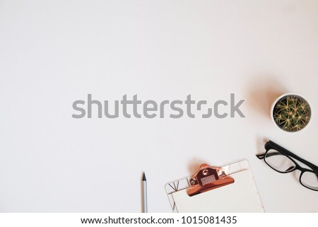 Minimal flat lay composition of feminine workspace, pencil, blank notebook, clipboard, glasses and cactus home plant. Student's desk, pink supplies. Copy space, background