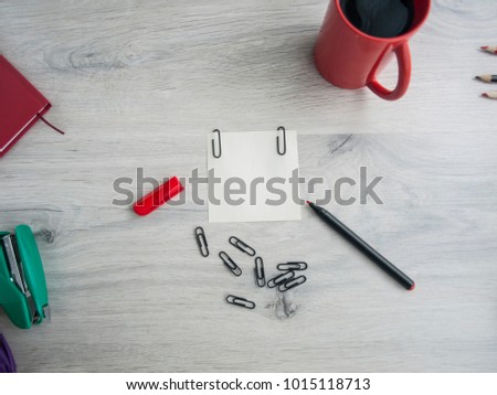 Office table with a set of color accessories, paper stickers, red marker, paper clips, stapler, coffee. Top view. Copy space.