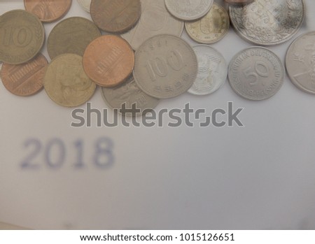 double exposure of coins and 2018 year calendar for financial background. gold and silver coins isolated for business growth background and copy space.