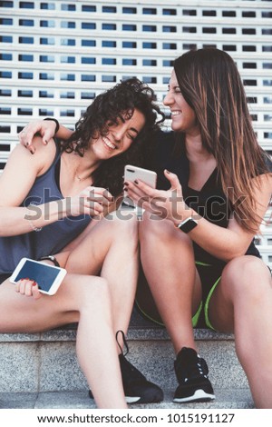 two beautiful women using a mobile in the Street.