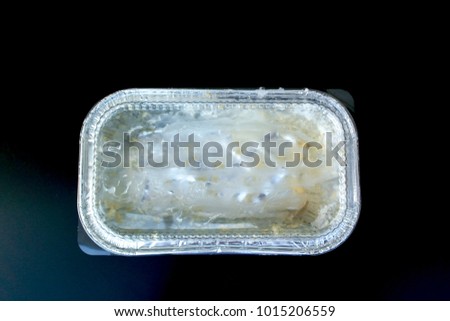 Used take-away food packaging on a black background