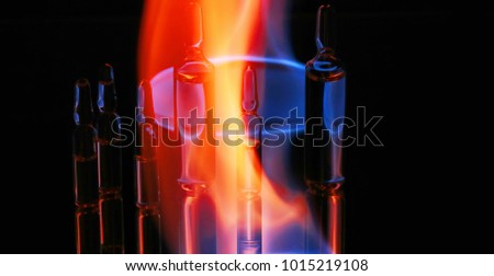 medical ampoules on fire. on a black background