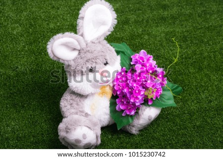 Plush bunny holding a bunch of flowers