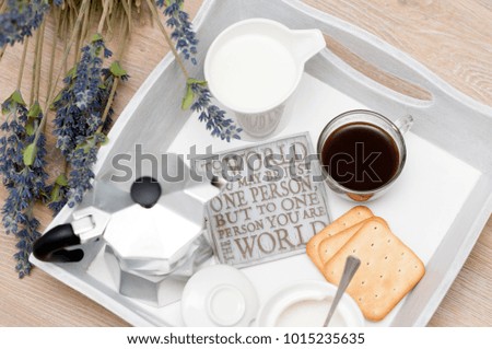 A festive breakfast of coffee in bed.
a tray with a cup of coffee, cream, cookies, sahorom and bouquet of flowers.
