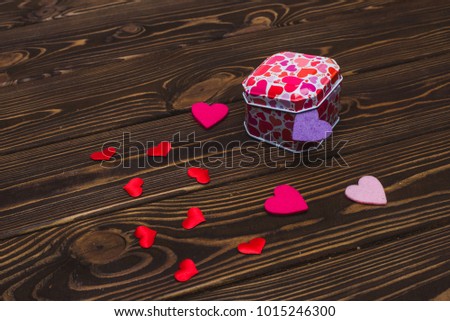 Red hearts on a tree of thread. Image of a tree with red hearts on a black wooden background.Photo with tinting