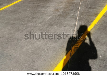 shadow man on street with yellow line