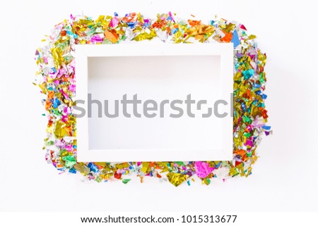 White photo frame with colorful paper on white background.flat lay, top view