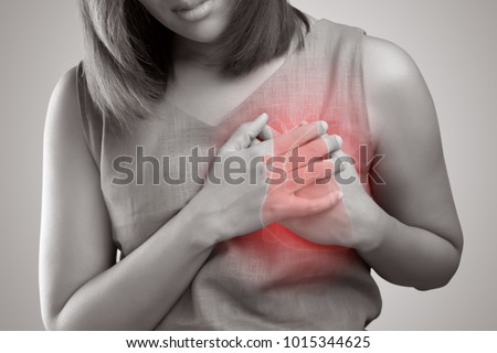 The photo of heart is on the woman's body, Severe heartache, Having heart attack or Painful cramps, Pressing on chest with painful expression. Royalty-Free Stock Photo #1015344625