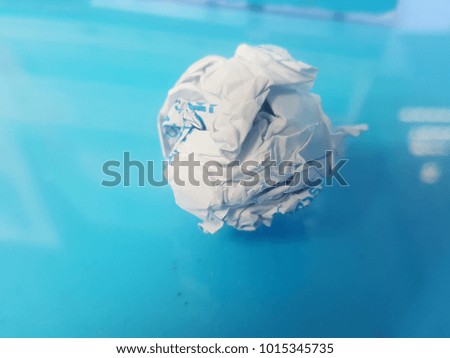 A piece of white paper pie placed on a blue glass.