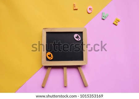 Text board with the letters "Love" on the pastel background.