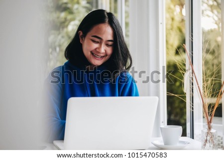 Beautiful Asian woman drinking coffee and working in coffee shop cafe 