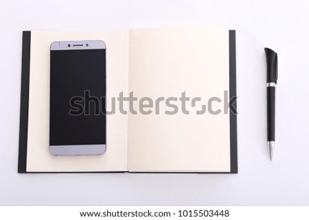 Business, education, education. Workplace, notepad for notes and pen. Mobile phone. White background.