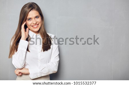 Business woman with folded hand standing against gray wall background. Copy space.