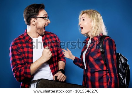 Happy smiling couple of handsome bearded funny man in glasses and blonde woman in a cowboy hat wearing red shirts together, a couple in love are traveling first time, friends on tour, Family trip