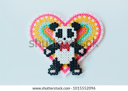 iron beads on white background. panda  with heart