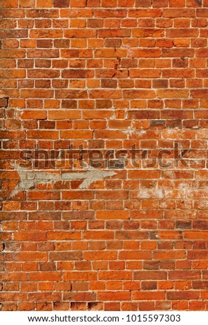 White Arrow Painted On Faded Red Textured Brick Wall. Direction Sign on Brickwall. Old Industrial Building With Uneven Surface.