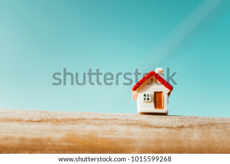 Closeup miniature house on blue sky background using as property and family concept - Vintage filter