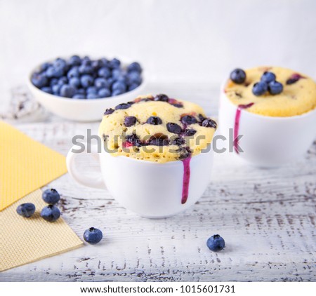 Homemade blueberry muffins mug cake with fresh berries on rustic wooden background Royalty-Free Stock Photo #1015601731