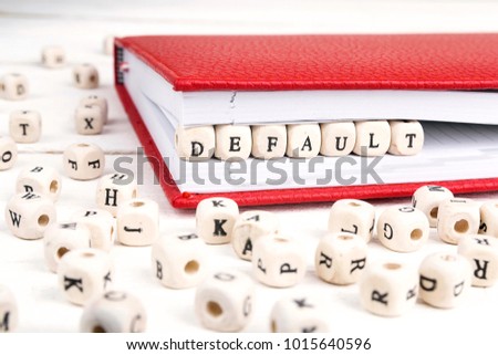 Word Default written in wooden blocks in red notebook on white wooden table. Wooden abc. Royalty-Free Stock Photo #1015640596
