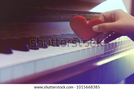 Red cartoon heart put on keyboard's piano, To tell love to learn music or to tell someone love in special day and valentine day.