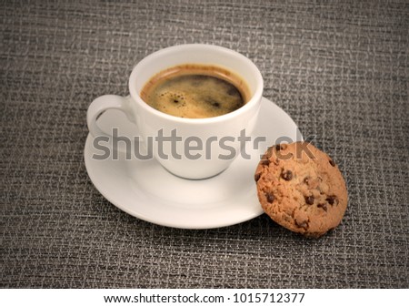 Chocolate cookie with coffee stock images. White cup of coffee with snack. Cup of coffee with cookie. Espresso with sweetness