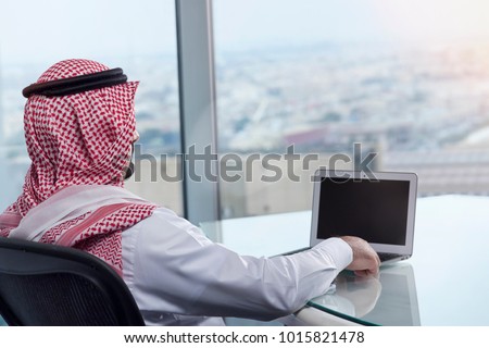 Saudi Arab Man Watching Laptop at Work and Contemplating Royalty-Free Stock Photo #1015821478