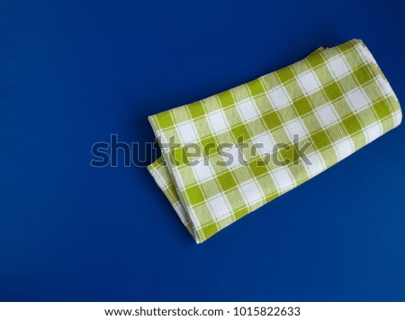 Green checked tablecloth on blue background