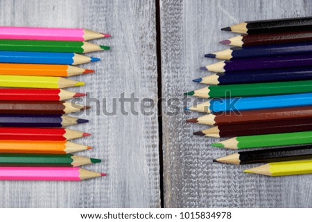 Colored pencils on grey wooden background