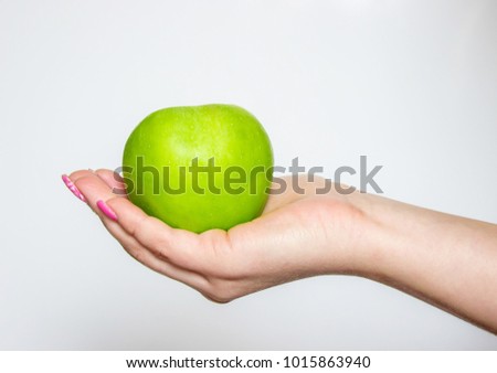 Green apple in hands. Selective focus.