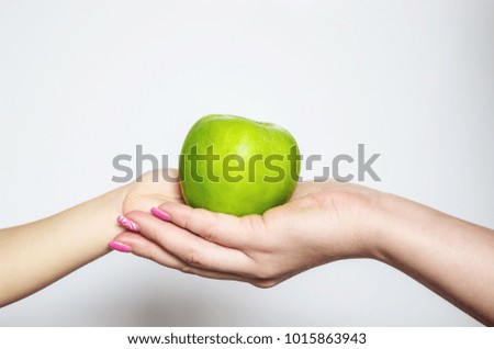 Green apple in hands. Selective focus.