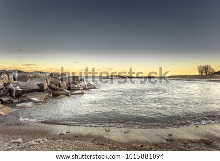 Metallic beach with yellow sunset and large rocks