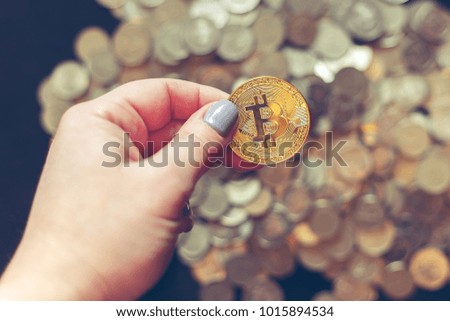 The female hand holds bitcoin. The concept of money, savings, pensions, finance. Selective focus, toned.