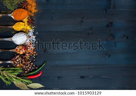 Spices in spoons on a blue wooden background. top view. with copy space