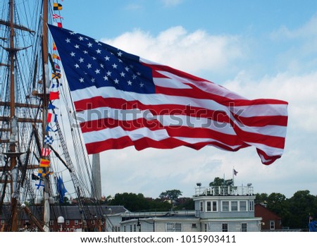 The American Flag beside a Tall Ship in Boston Harbor