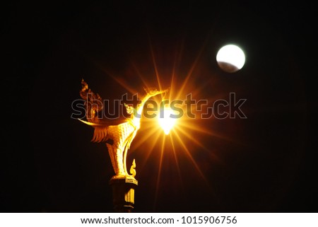 Lunar eclipse with street lamp foreground