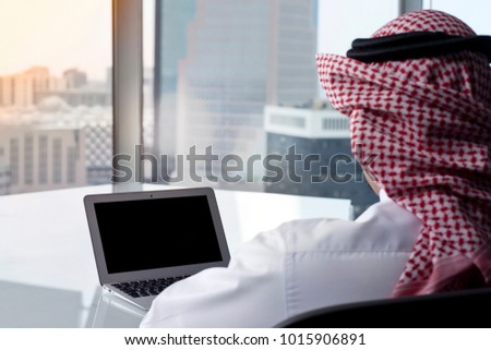 Saudi Arab Man Watching Laptop at Work and Contemplating Royalty-Free Stock Photo #1015906891