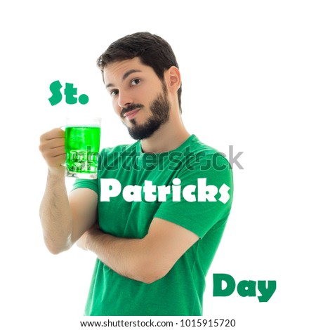 Male offers mug of bier. Young man wearing green clothes on white background, related to Saint Patrick's day.