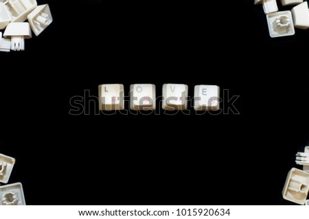 Word "LOVE" with "ENTER" button made of white computer keyboard keys on isolated black background surrounded by others white computer keyboard keys in the corners