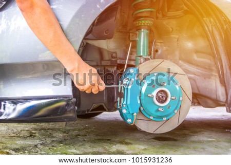 Hand and man remove nut lock caliper pad on the caliper repair concept and maintenance of car sunset light background