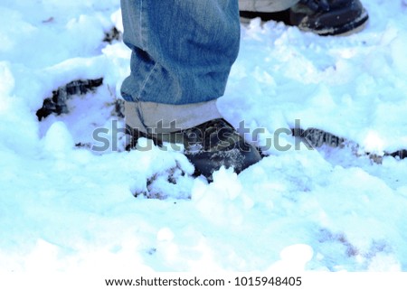 Close-up of men legs that falling down on snow. Partial of man's winter jeans and boots covering on snow.