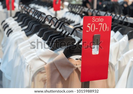Sale 50-70% mock up advertise display frame on row of hanging apparel in shopping center