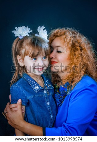 On a black background with a mother hugging her daughter. They love each other and are very happy.
