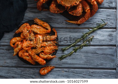 Seafood. Top view, breakfast. Shrimp, crab, cooked. On a wooden background with rosemary branches