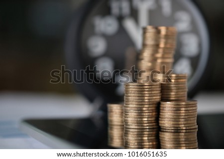 Step of coins stacks and alarm clock with tablet computer and financial graph, business planning vision and finance analysis concept idea.
