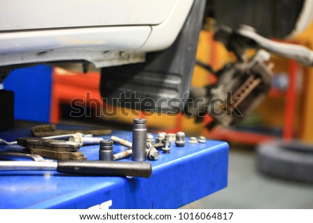 Tools and bolt nut during technician repair car
