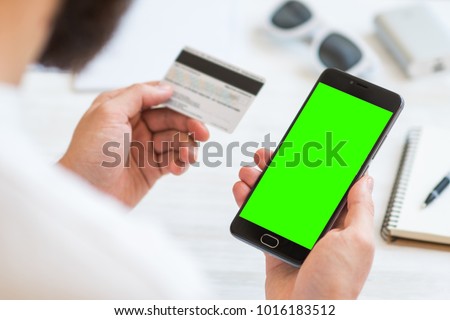 Closeup photo businessman holding hand credit card and using smartphone. Online payments plastic card. Horizontal mockup. Blurred, film effect