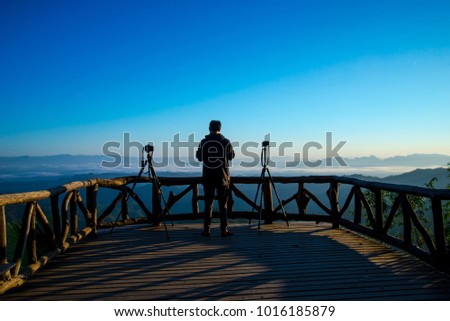The man take a photo on mountain viewpoint