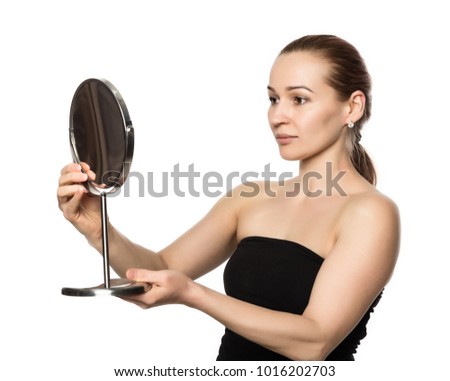 young woman performs anti-aging exercises. face fitness. girl looks in the mirror