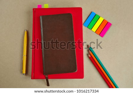 office supplies, notebooks, pen, pencils, bookmarks, on a paper background