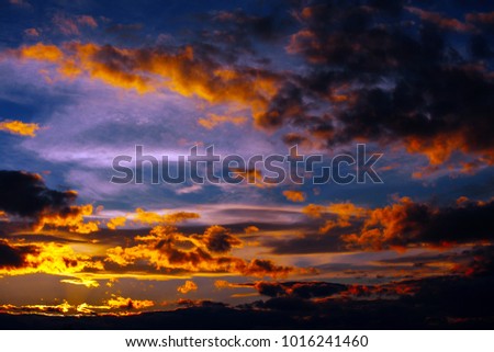Large bright orange clouds on a blue sky during sunset. Beautiful sky on twilight time.